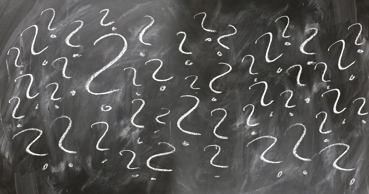 A person looking confused with question marks around their head.