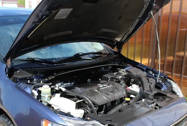 The engine bay of a car with an MOT failure certificate.