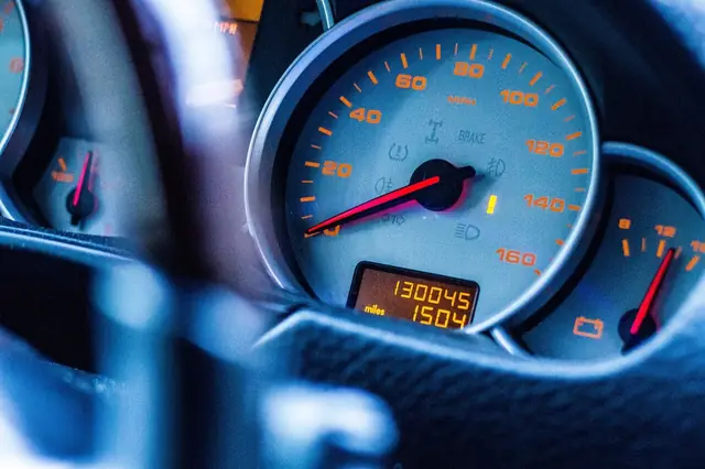 A car dashboard with a check engine light on.